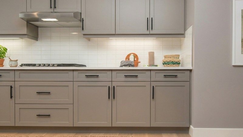 painted gray kitchen cabinets with black matte hardware after DIY paint job